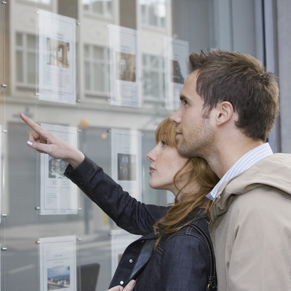 Couple looking in estate agents window